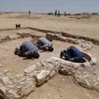 Muslim workers for the Israeli Antiquities Authority pray at the newly discovered remains of an ancient rural mosque in Rahat on July 18. | AFP-JIJI