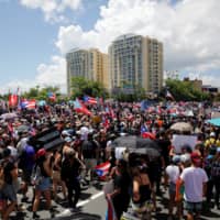 People take part in a protest calling for the resignation of Gov. Ricardo Rossello in San Juan Monday. | REUTERS