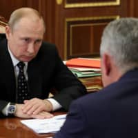 Russian President Vladimir Putin and Defense Minister Sergei Shoigu hold a meeting in Moscow on Thursday on the recent accident involving a deep-water submersible. | AFP-JIJI