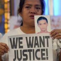 A woman displays a picture of her son, a drug war victim, and a placard during a protest over the war on drugs by President Rodrigo Duterte in Quezon city, Metro Manila, Philippines, last August 28. | REUTERS