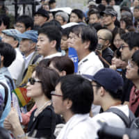 Spectators listen to a candidate during a campaign rally in Tokyo on July 15. | BLOOMBERG