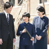 Prince Hisahito, along with his parents Crown Prince Akishino and Crown Princess Kiko,  attend a graduation ceremony at his Tokyo elementary school in March. | KYODO