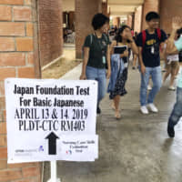 A sign directs test-takers toward a Japanese-language exam in Manila in April for those who want to work in Japan under a new visa category. Japan is planning to conduct language tests in other countries in the autumn. | KYODO
