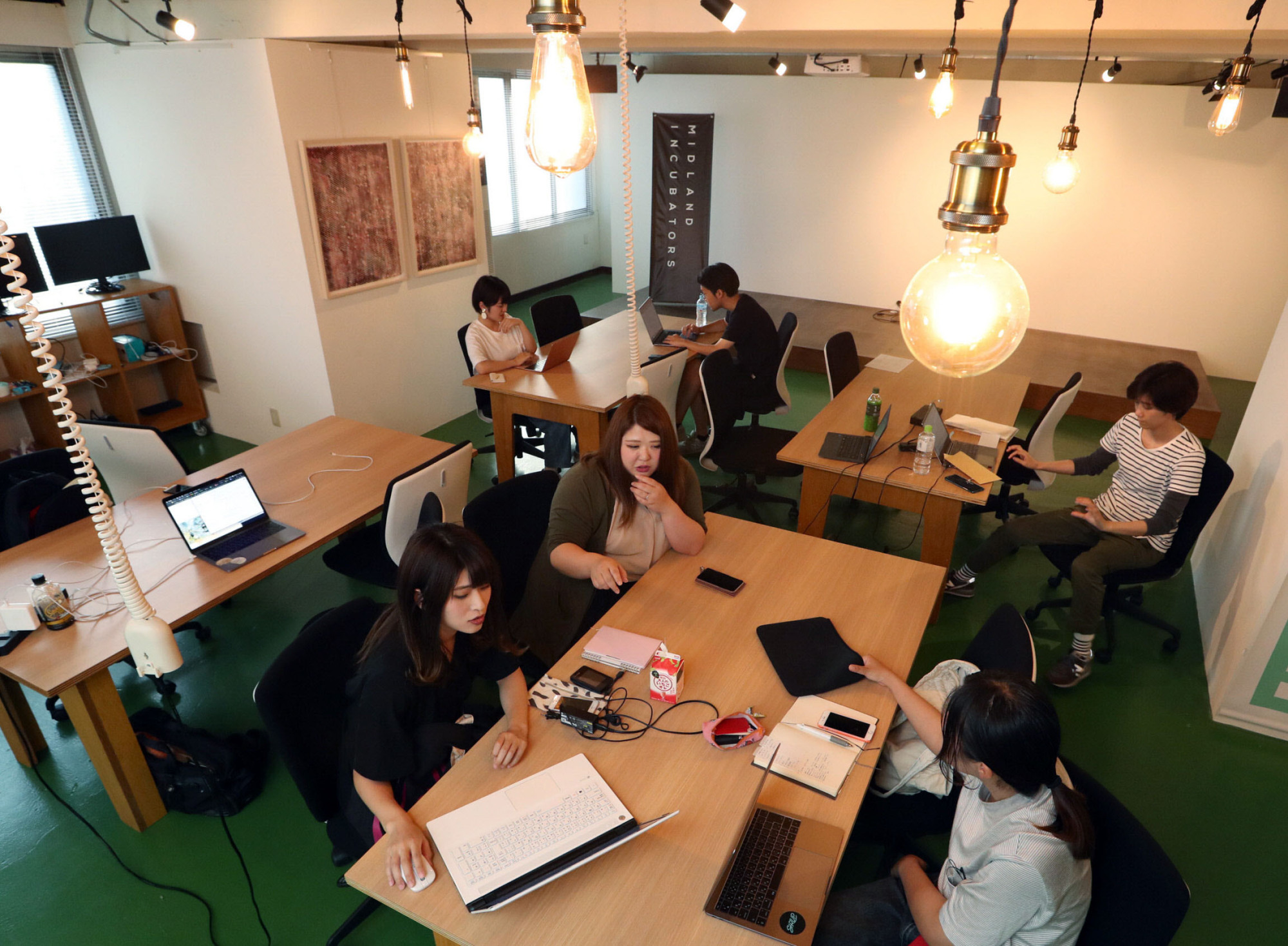 People gather at Kamejima Garage, a coworking space in Nagoya's Nakamura Ward for entrepreneurs and students seeking to start a business. | CHUNICHI SHIMBUN