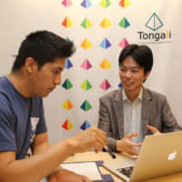 Masahiro Tsukamoto (right), president of Nagoya- based Harmony For Inc., offers consulting services to a foreign student at Nagoya University. | CHUNICHI SHIMBUN