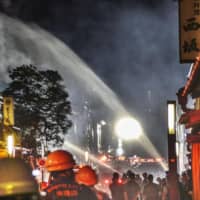 Firefighters try to extinguish a fire in the Gion district of Kyoto on Monday night. | KYODO