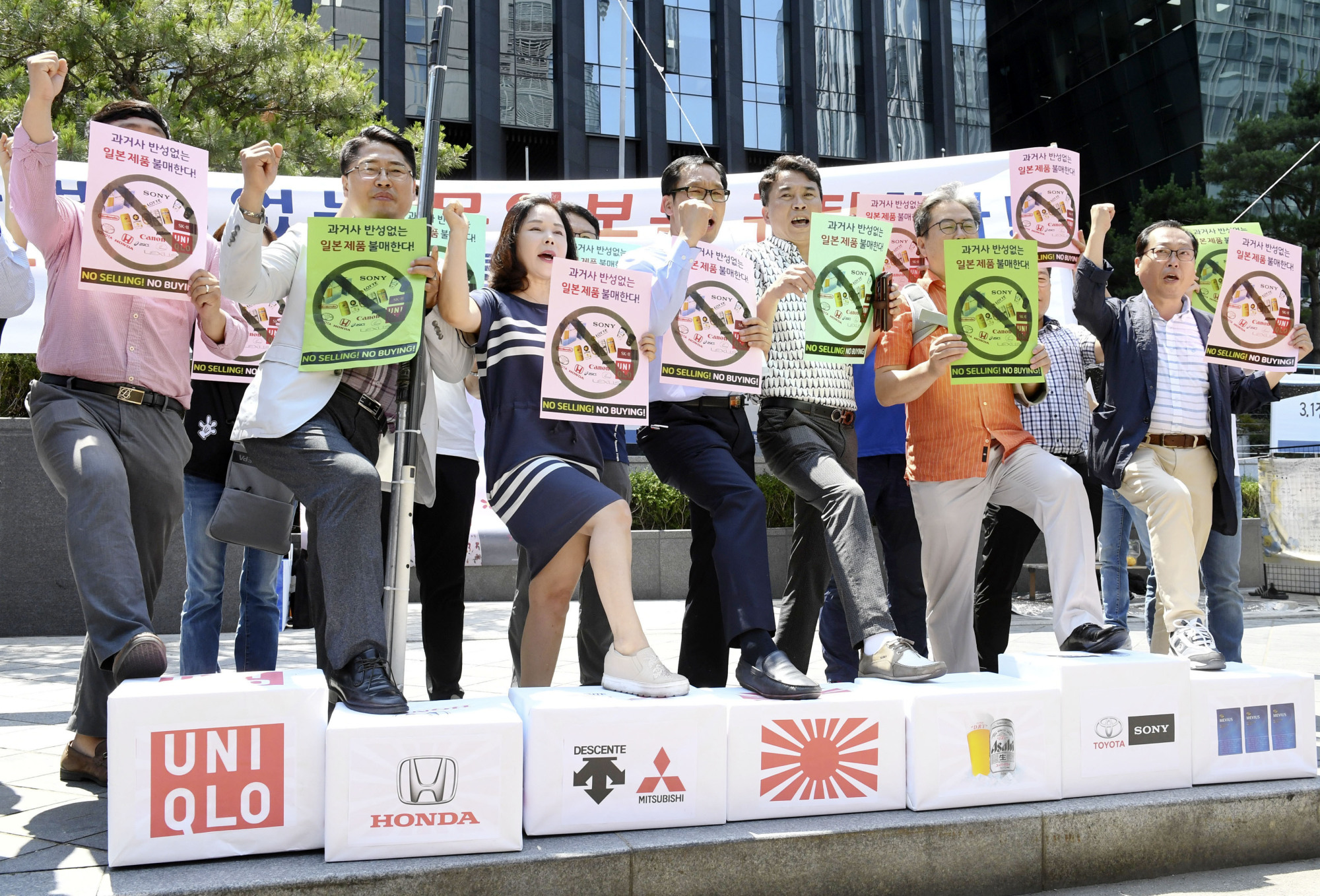 South Korean business owners stamp on boxes bearing the logos of Japanese companies, during a protest in Seoul on July 5 against Japan's tightening of rules on exports to South Korea. | KYODO