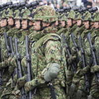 Members of the Self-Defense Forces march during a review at Ground Self-Defense Force Camp Asaka in Saitama Prefecture in October 2018. | BLOOMBERG