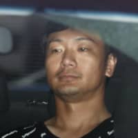 Hisato Fujiki is taken to a police station in Kumamoto Prefecture on Sunday after turning himself in to the police in neighboring Fukuoka. | KYODO