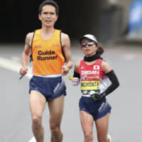 Misato Michishita runs with a guide during the women\'s pararace in the London Marathon on April 28. | REUTERS