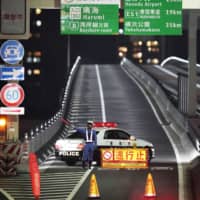 A police officer blocks an entrance to an expressway during a large-scale test in Tokyo on Wednesday that is aimed at cutting down on traffic during the 2020 Tokyo Olympics and Paralympics. | KYODO