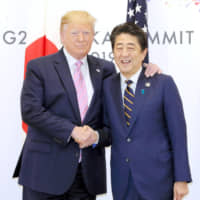 Prime Minister Shinzo Abe shakes hands with U.S. President Donald Trump in Osaka on June 28 during their meeting on the sidelines of a Group of 20 summit. | KYODO
