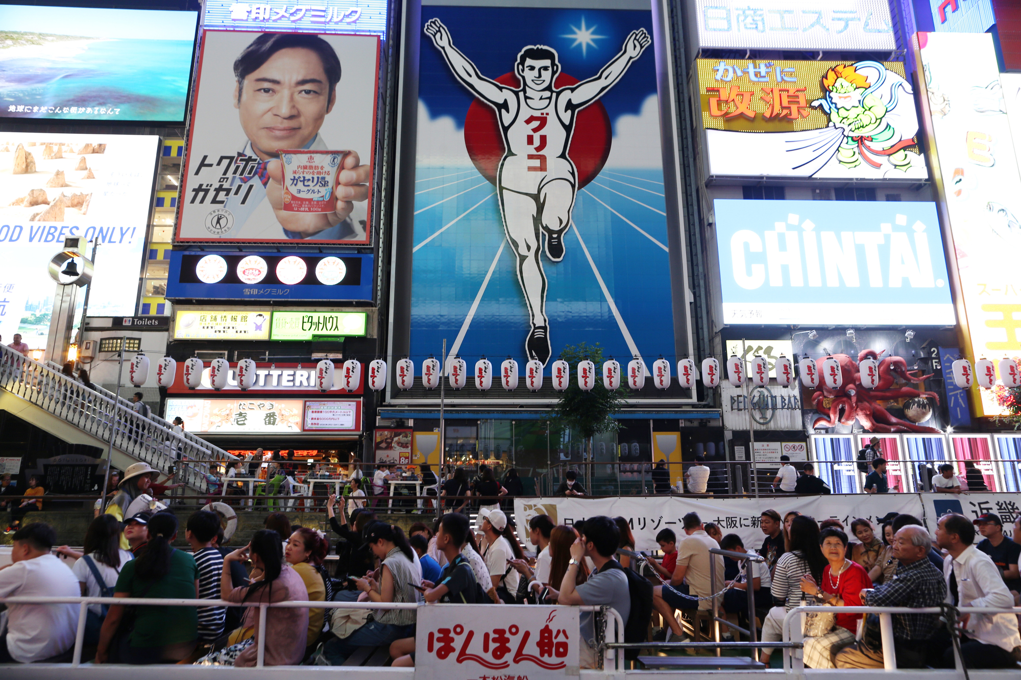 People walk around the Dotonbori downtown area of Osaka last month. Japan saw a record 16.63 million overseas visitors in the first six months of this year, according to government data released Wednesday. | BLOOMBERG