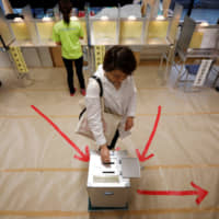 A voter casts her ballot at a voting station in Tokyo in Sunday\'s Upper House election. | REUTERS