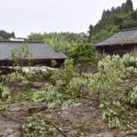 Houses are seen buried in mud in the town of Mashiki, Kumamoto Prefecture, on Monday after heavy rain triggered landslides. | KYODO