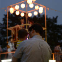 Quality time: A man and a young child take part in a summer festival. The Japanese government hopes the nation\'s fathers can take paternity leave. | KYODO