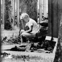 Andy Aldrin, 10, sits in the backyard of his home in Houston while other members of his family listen to the reports of the progress of the Apollo 11 lunar module carrying his father, Col. Buzz Aldrin and fellow astronaut Neil Armstrong to a landing on the moon on July 20, 1969. | AP