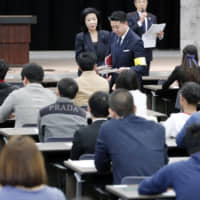 Growing responsibilities: A proctor administers a test on Japanese language to a group of non-Japanese individuals. | KYODO