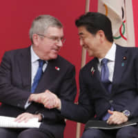 Prime Minister Shinzo Abe shakes hands with International Olympic Committee President Thomas Bach during the \"One Year to Go\" Olympic ceremony event in Tokyo on Wednesday. | AP