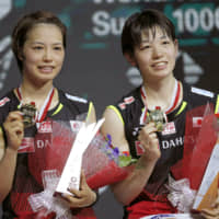 Yuki Fukushima (left) and Sayaka Hirota pose with their gold medals after defeating Misaki Matsutomo and Ayaka Takahashi in the women\'s doubles final match at the Indonesia Open badminton championship in Jakarta on Sunday. | AP