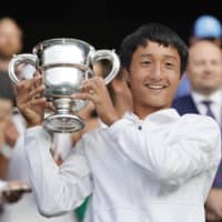 Shintaro Mochizuki celebrates after winning the Wimbledon boys\' title on Sunday at the All England Club. | KYODO
