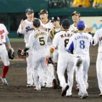 Central League All-Stars congratulate each other after their 11-3 victory over the Pacific League in Game 2 of the NPB All-Star Series on Saturday night at Koshien Stadium. | KYODO
