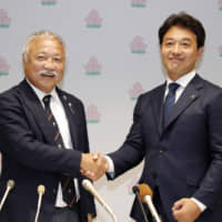 New JRFU president Shigetaka Mori (left) shakes hand with Kensuke Iwabuchi, the Japan men\'s sevens national team head coach, during a news conference on June 29 in Tokyo. | KYODO