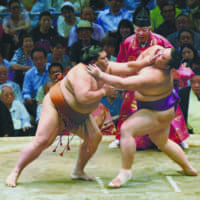 Sekiwake Mitakeumi (left) battles No. 1 maegashira Asanoyama on Saturday at the Nagoya Grand Sumo Tournament. | NIKKAN SPORTS