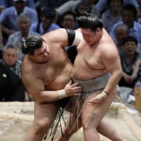 Takayasu (left) pushes Meisei out of the ring on Tuesday at Dolphins Arena in Nagoya during the 10th day of the Nagoya Grand Sumo Tournament. | KYODO