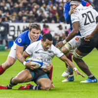 France\'s Antoine Dupont tackles Fiji\'s Henry Seniloli in a test match on Nov. 24, 2018, in Paris. | GETTY IMAGES / VIA KYODO