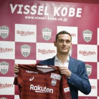 Defender Thomas Vermaelen holds up his new Vissel Kobe shirt at his introductory news conference in Kobe on Saturday. KYODO PHOTO | KYODO