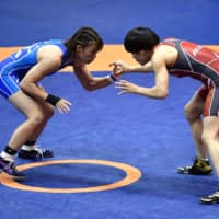 Kaori Icho (right), a four-time defending Olympic champion, grapples with Risako Kawai in a 57-kg qualification playoff match on Saturday in Wako, Saitama Prefecture. | KYODO