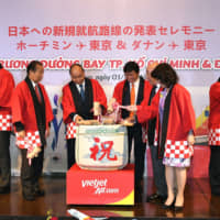 VietJet Air announces the launch of two new routes (Narita to Ho Chi Minh City and Haneda to Danang), celebrating with a kagamiwari sake barrel-breaking ceremony. Toshihiro Nikai (far left), chairman of the Japan-Vietnam Parliamentary Friendship League and secretary-general of the Liberal Democratic Party, breaks open a barrel with (from second from left) Vietnamese Prime Minister Nguyen Xuan Phuc; Nguyen Thanh Hung, vice chairman of VietJet\'s board of directors; Isao Iijima, special adviser to the Cabinet; and Satsuki Katayama, minister of state for regional revitalization, at New Otani Hotel on July 1. | YOSHIAKI MIURA