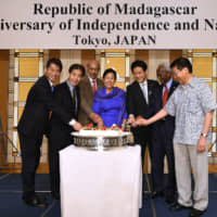 Madagascan Ambassador Mireille Mialy Rakotomalala (center) poses with (from left) Parliamentary Vice-Minister for Foreign Affairs Kenji Yamada; Chairperson of the Japan-African Union Parliamentary Friendship League Ichiro Aisawa; Eritrean Ambassador and Dean of the African Diplomatic Corps in Tokyo Afeworki Haile Estifanos; Kentaro Sonoura , special adviser to the prime minister; Djiboutian Ambassador and President of La Francophonie in Japan\'s promotion board Ahmed Araita Ali; and Asahiko Mihara, acting chairperson of the Japan-African Union Parliamentary Friendship League during a cake-cutting ceremony to celebrate Madagascar\'s 59th independence day at Hotel Okura Tokyo on      June 27.  | YOSHIAKI MIURA