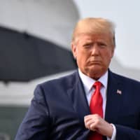 U.S. President Donald Trump walks after stepping off Marine One upon arrival to Manchester, New Hampshire, to hold a \"Keep America Great\" campaign rally Aug. 15. President Trump is so convinced that his re-election depends on the economy staying strong that the merest hint of recession has sent him into political crisis management mode. | AFP-JIJI