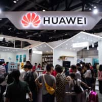 Attendees visit a Huawei exhibition stand during the Consumer Electronics Expo in Beijing Aug. 2. | AFP-JIJI