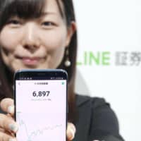A demonstration of Line Securities Corp.\'s stock trading using a smartphone application is seen in Tokyo on Tuesday. | KYODO