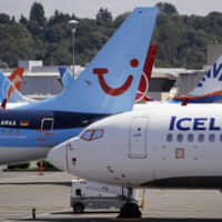 Dozens of grounded Boeing 737 MAX airplanes, including one for Icelandair and TUI Airlines, crowd a parking area adjacent to Boeing Field Aug. 15 in Seattle. | AP