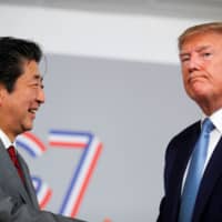 U.S. President Donald Trump and and beeming Japanese Prime Minister Shinzo Abe hold a bilateral meeting during the G7 summit in Biarritz, France, Sunday. | REUTERS
