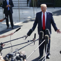 U.S. President Donald Trump speaks to members of the media before boarding Marine One on the South Lawn of the White House on Tuesday. | BLOOMBERG