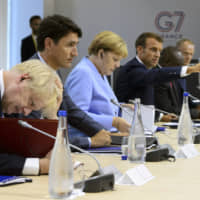 Canadian Prime Minister Justin Trudeau sits between British Prime Minister Boris Johnson (left) and German Chancellor Angela Merkel as they take part in a meeting at the G7 Summit in Biarritz, France, Monday. Gesturing at right is French President Emmanuel Macron. | SEAN KILPATRICK / THE CANADIAN PRESS / VIA AP