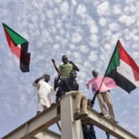 Sudanese protesters from the city of Atbara arrive at the Bahari Station in Khartoum on Saturday to celebrate the nation:s transition to civilian rule. | AFP-JIJI
