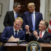 U.S. President Donald Trump talks with European Union Ambassador Stavros Lambrinidis as U.S. Trade Representative Robert Lighthizer (front right) and Jani Raappana, deputy head of mission for the Finnish presidency of the Council of the EU, sign an agreement expanding U.S. beef exports to the European Union, in the Roosevelt Room of the White House on Friday. | AP