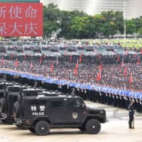 Chinese police officers hold a riot drill in Shenzhen, across the border from Hong Kong, on Wednesday. | AFP-JIJI