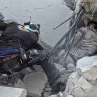 A member of the Syrian Civil Defense (White Helmets) recovers a body from the rubble after a reported airstrike by regime planes on the town of Maaret Hurmah in the southern countryside of Syria\'s northwestern Idlib province on Wednesday. An agreement between the United States and Turkey to establish a safe zone in northwest Syria will be implemented gradually, with some operations beginning soon, a Pentagon spokesman said Thusday. | AFP-JIJI