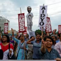 People shout slogans as they carry an effigy depicting Kuldeep Singh Sengar, a legislator of the ruling Bharatiya Janata Party (BJP), during a protest demanding justice for a woman who is fighting a rape case against the legislator in Kolkata, India, Wednesday. | REUTERS