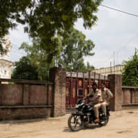 Policemen ride past the house of Kuldeep Singh Sengar, a legislator of the ruling Bharatiya Janata Party (BJP) who is accused of raping a young woman, in Unnao, in the northern state of Uttar Pradesh, India, Wednesday. | REUTERS