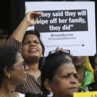 Indian women participate in a protest to condemn a deadly car crash that left a woman who accused a politician of rape in critical condition, in Mumbai Thursday. | AP
