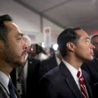 Rep. Joaquin Castro (left) stands next to his brother Julian Castro in the spin room following the Democratic presidential candidate debate in Detroit on July 30. | BLOOMBERG