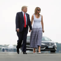 U.S. President Donald Trump and U.S. first lady Melania Trump walk on a tarmac as they return from the G7 summit, in Bordeaux, France, Monday. | REUTERS